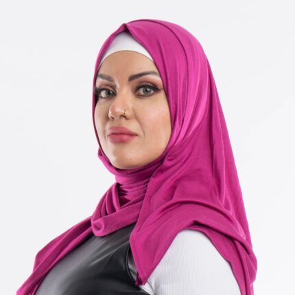 Woman wearing a vibrant fuchsia premium jersey hijab styled with a front drape, demonstrating the soft and opaque fabric.