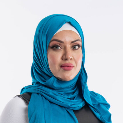 Woman wearing an aqua blue premium jersey hijab styled with an elegant front drape, showing the soft and opaque fabric.