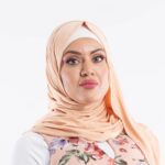 Woman wearing a warm camel premium jersey hijab styled with an elegant front drape, showing the soft and opaque fabric.