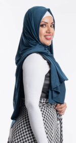 Side profile of a woman wearing the dark teal premium jersey hijab, highlighting the comfortable, pin-free stretch fit.