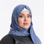 Woman wearing a denim blue premium jersey hijab styled with a front drape, demonstrating the soft and opaque fabric.