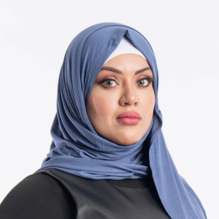 Woman wearing a denim blue premium jersey hijab styled with a front drape, demonstrating the soft and opaque fabric.