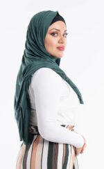 Side profile of a woman wearing the forrest green premium jersey hijab, highlighting the comfortable, pin-free stretch fit.
