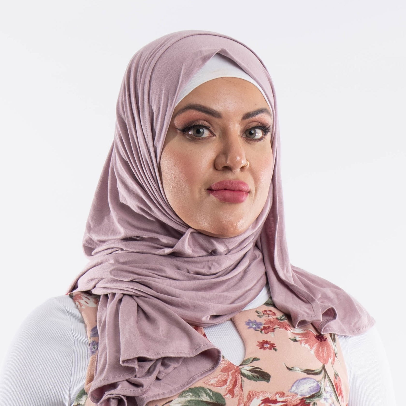 lavender-premium-jersey-hijab-front-drape Woman wearing a soft lavender premium jersey hijab styled with a front drape, demonstrating the smooth and opaque fabric.