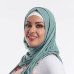 Woman wearing a fresh mint green premium jersey hijab styled with a front drape, demonstrating the smooth and opaque fabric.