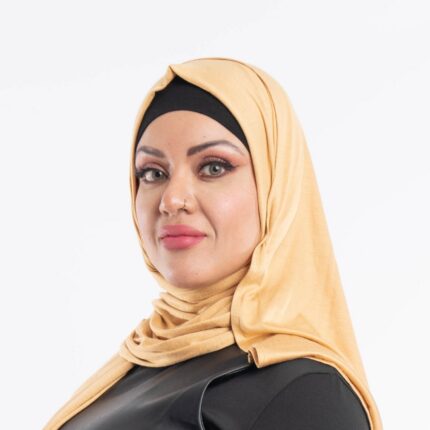 Woman wearing a warm mustard yellow premium jersey hijab styled with a front drape, demonstrating the soft and opaque fabric.