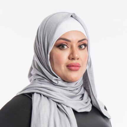 Woman wearing a sleek mystic grey premium jersey hijab styled with an elegant front drape, demonstrating the smooth and opaque fabric.
