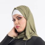 Woman wearing a rich olive green premium jersey hijab styled with an elegant front drape, demonstrating the smooth and opaque fabric.