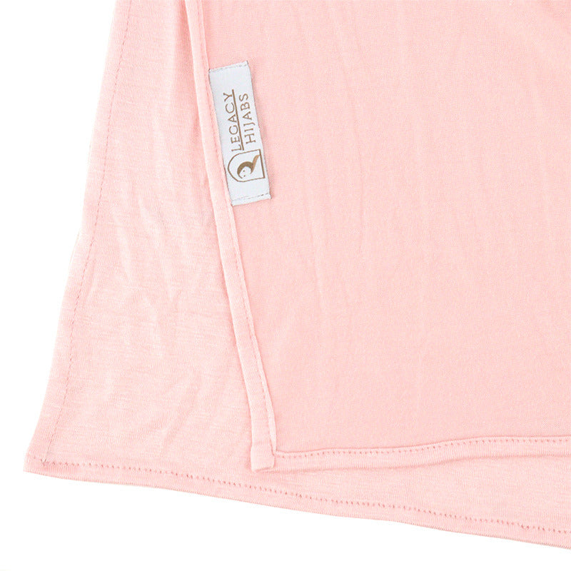 Neatly folded pink premium jersey hijab on a flat surface, showcasing its vibrant pink color and medium-weight fabric.