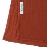 Neatly folded sienna premium jersey hijab on a flat surface, showcasing its earthy reddish-brown tone and medium-weight fabric.